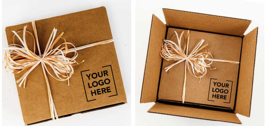 Two kraft corporate holiday gift boxes tied with raffia ribbon and stamped with a custom company logo, packed for a bulk order by Connect Gifting